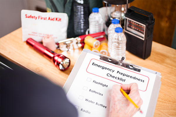 Image: Emergency preparedness checklist on a clipboard and earthquake kit supplies