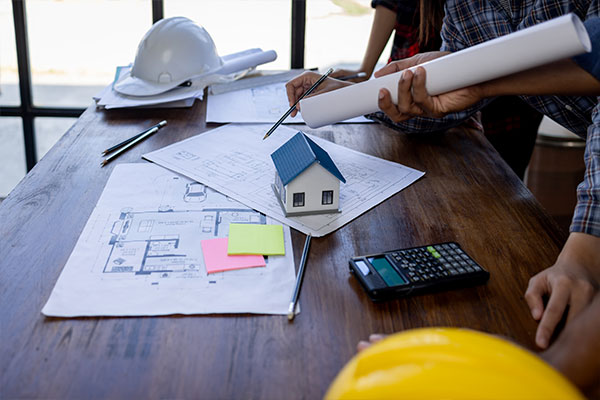 Image: Contractors with hard hat looking at retrofit blue prints