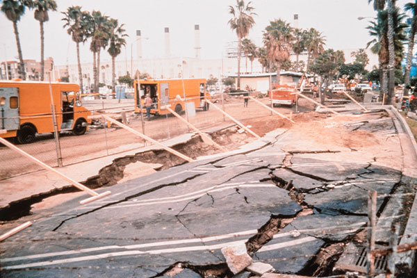 Image: Craked and damaged road with first responders